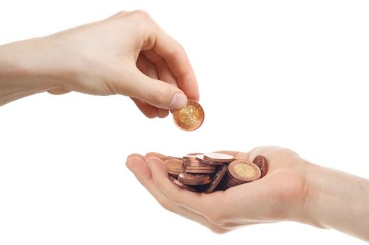 Zwei Hände vor weißem Hintergrund: Eine Hand hält mehrere Münzen, während die andere Hand eine einzelne Münze übergibt.