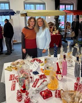Zwei Mitarbeiter der Krebshilfe Oberösterreich vor dem Spendentisch am Weihnachtsmarkt Haslach