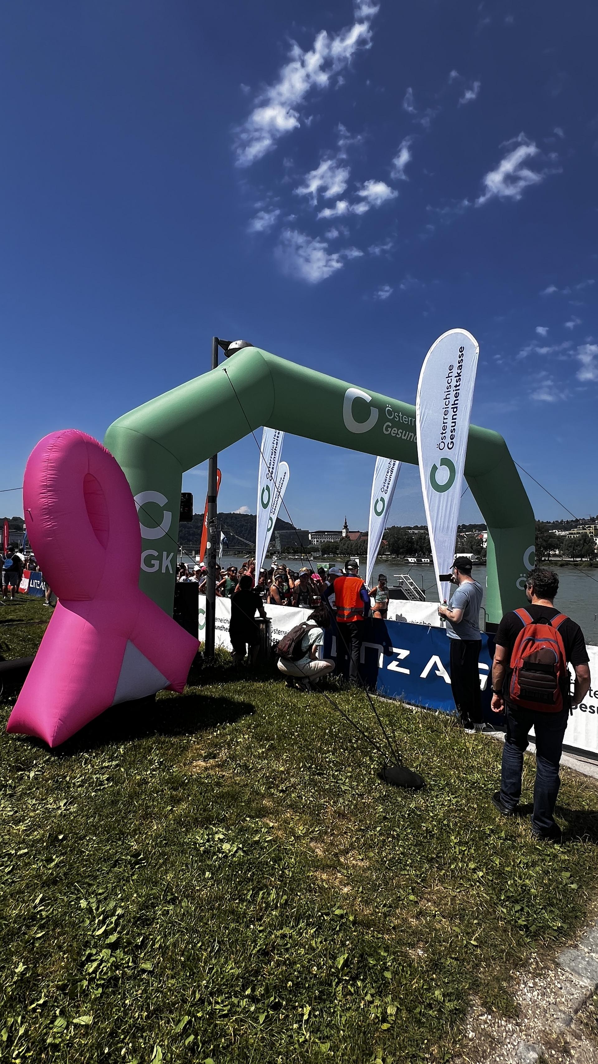 Start des Frauenlaufs mit Bannern und Flyern der ÖGK und ein Blow-up Pink Ribbon