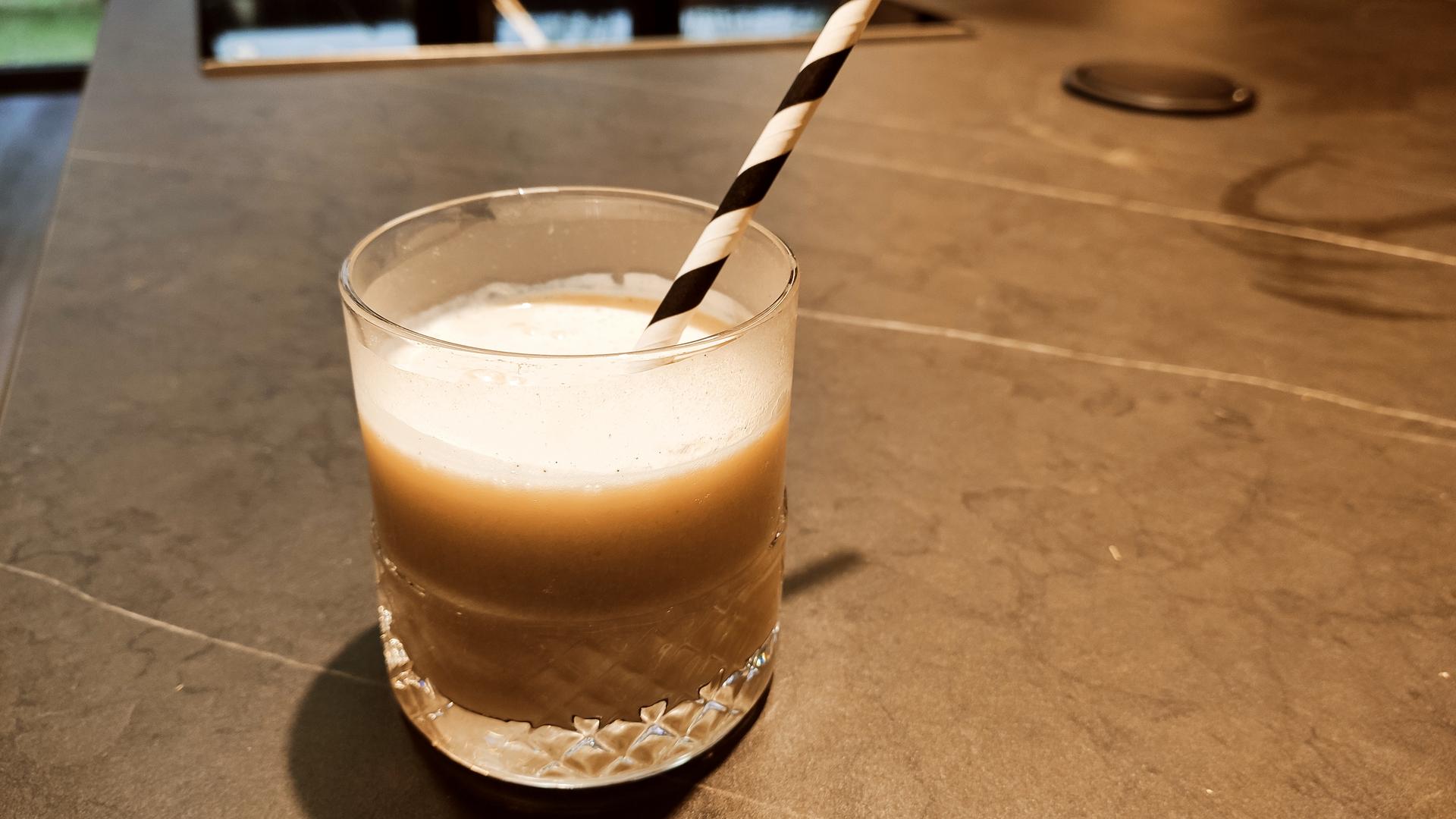 Mandel-Bananenmilch im Glas auf einer Tischplatte