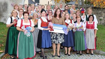 Goldhaubendamen Perg in Tracht mit Maria Sauer, die den Spendencheck in der Hand hält.